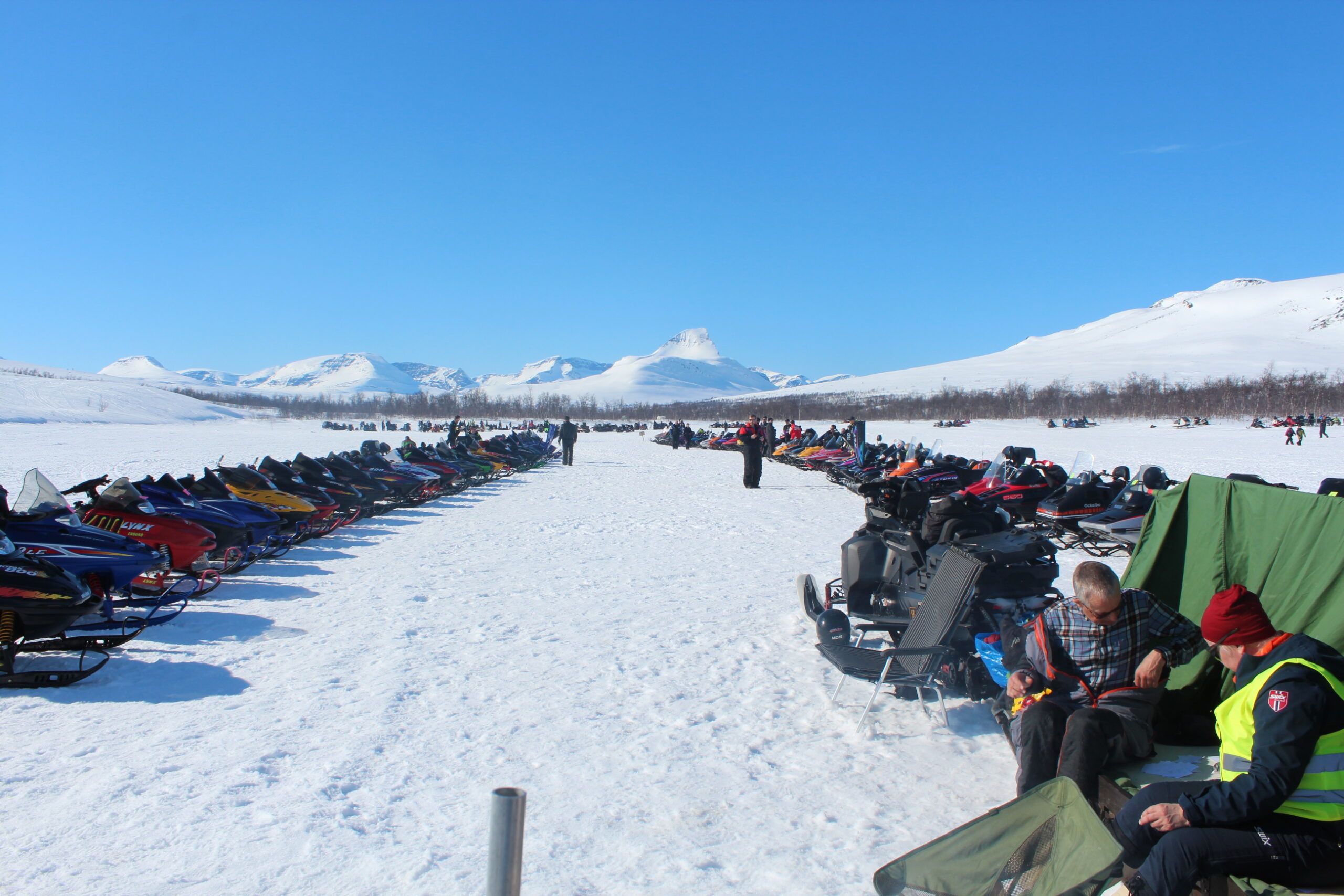 Topp forhold på fjellet med årganger av snøscootere og isfiske for små og store